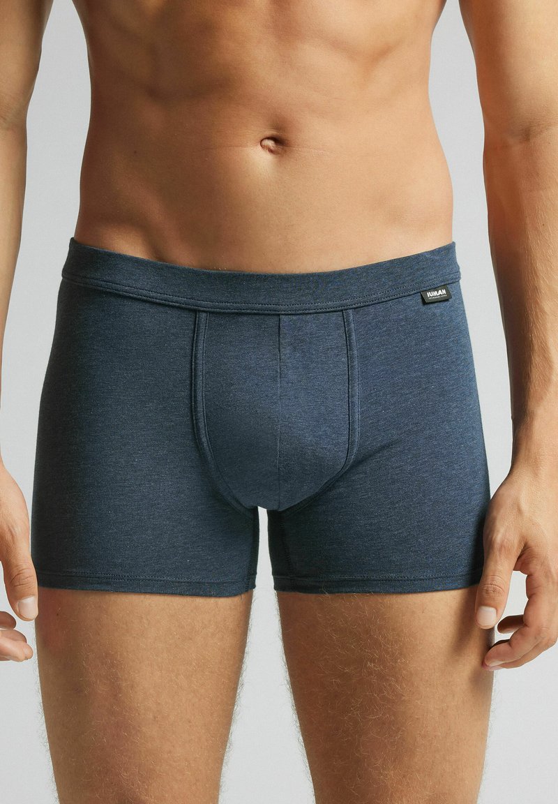 Pánské tmavě modré boxerky vyrobené z měkké tkaniny, mají hladký pás, viditelné švy a tvarovaný design pánské šalby.