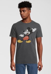 Grå kortærmet t-shirt med et vintage Mickey Mouse-grafik i sort, rød og gul. Den er lavet af blødt bomuldsstof og har en almindelig pasform.