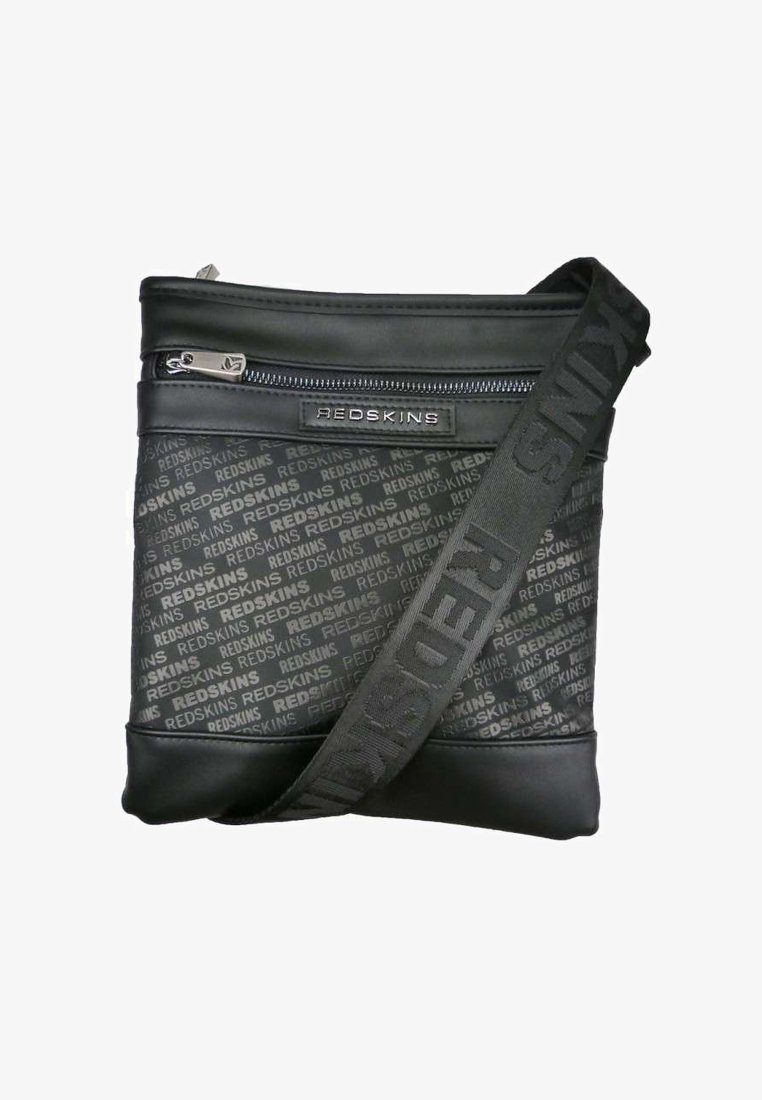 Sac bandoulière noir en matériau synthétique lisse. Il dispose d'une fermeture zippée, d'une surface à motif et d'une bandoulière ajustable avec le logo "REDSKINS".