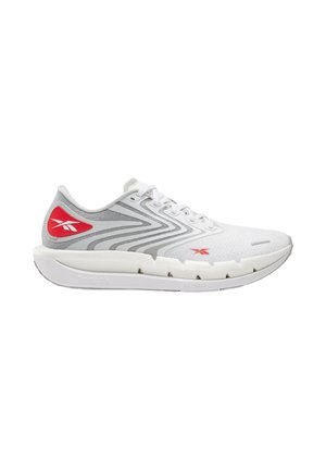 Zapatilla deportiva blanca y gris con logos rojos de Reebok, diseño con cordones y suela gruesa acolchada con ranuras segmentadas.