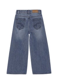 Tył niebieskich spodni dżinsowych z szerokimi nogawkami, z dwiema tylkimi kieszeniami, szlufkami na pasek i brązową skórzaną naszywką na pasku. 