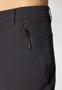 Svarte atletiske shorts med elastisk midjebånd, sidelomme med glidelås og jevn, lett stoff med tettsittende passform.