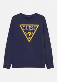 Granatowa bluza z długim rękawem z żółtym logo w kształcie trójkąta z napisem "GUESS" oraz "U.S.A." na środku.