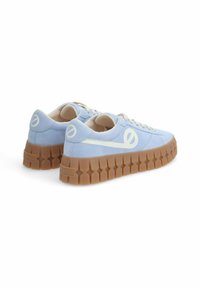Baskets en velours bleu avec une semelle épaisse beige, arborant un logo blanc sur le côté et des lacets beiges contrastants. Design à bout arrondi.