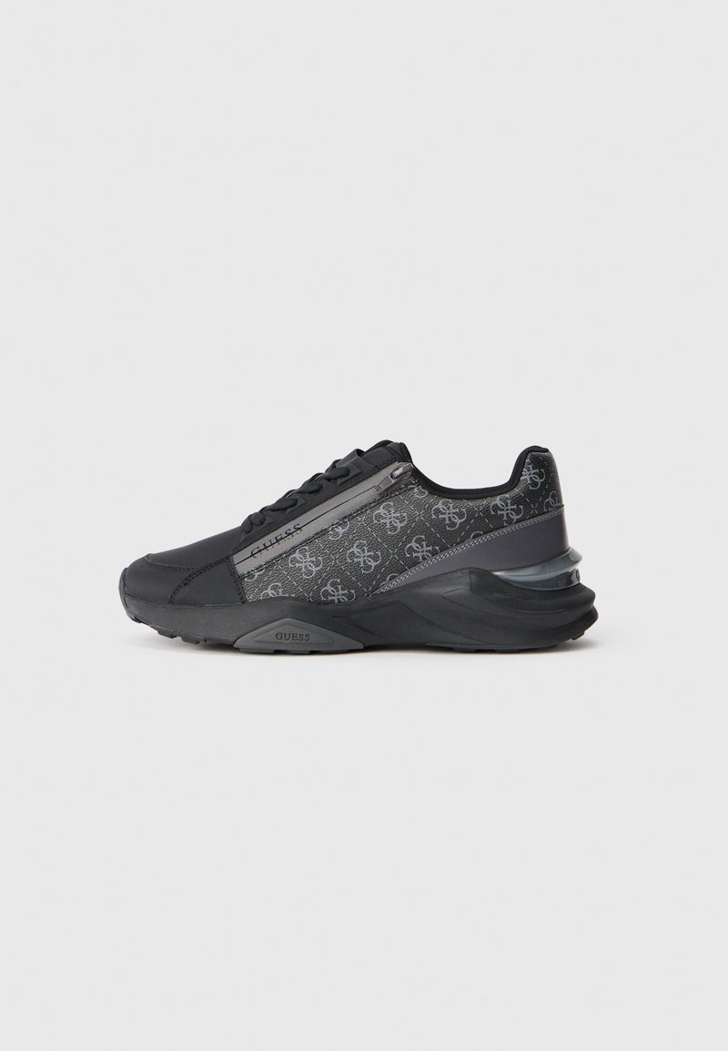 Black and gray low-top sneaker with monogram pattern, zipper detail, lace-up front, and thick cushioned sole.