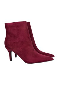 Botines de ante burdeos con puntera afilada y un tacón alto y delgado. Textura suave con un diseño sin costuras; sin herrajes ni patrones visibles.