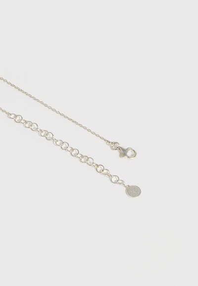 Ασημένιο κολιέ με αλυσίδα, κόμπλερ με καβούκι και ρυθμιζόμενους κρίκους, που καταλήγει σε ένα μικρό στρογγυλό μενταγιόν με εγχάραξη "M".