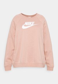 Różowa bluza z okrągłym dekoltem, długimi raglanowymi rękawami i dużym białym logo Nike na piersi. Miękka, teksturowana tkanina.