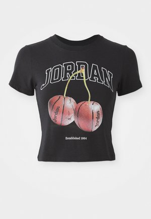Melnas kokvilnas īsām piedurknēm T-krekls ar baltu uzrakstu "JORDAN" un diviem sarkaniem ķiršiem, kas atgādina basketbola bumbas. Akcenti ietver "Izveidots 1984."