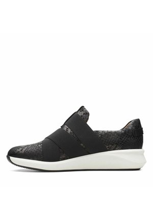 Zapatilla negra tipo slip-on con parte superior de imitación de piel de serpiente texturizada y bandas elásticas anchas. Suela media blanca con ligera elevación en el talón.