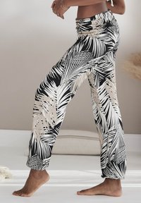 Zwarte en beige broek met palmbladvormige patronen, voorzien van een verzamelde tailleband en rechte pijpen, gemaakt van lichtgewicht stof, met een relaxte pasvorm.