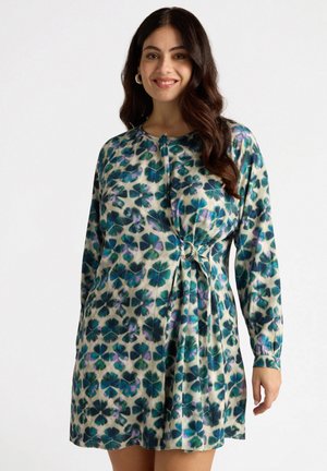Vestido de manga larga hecho de una tela suave con un patrón floral en tonos de verde, azul y púrpura. Presenta un detalle de nudo en la cintura.