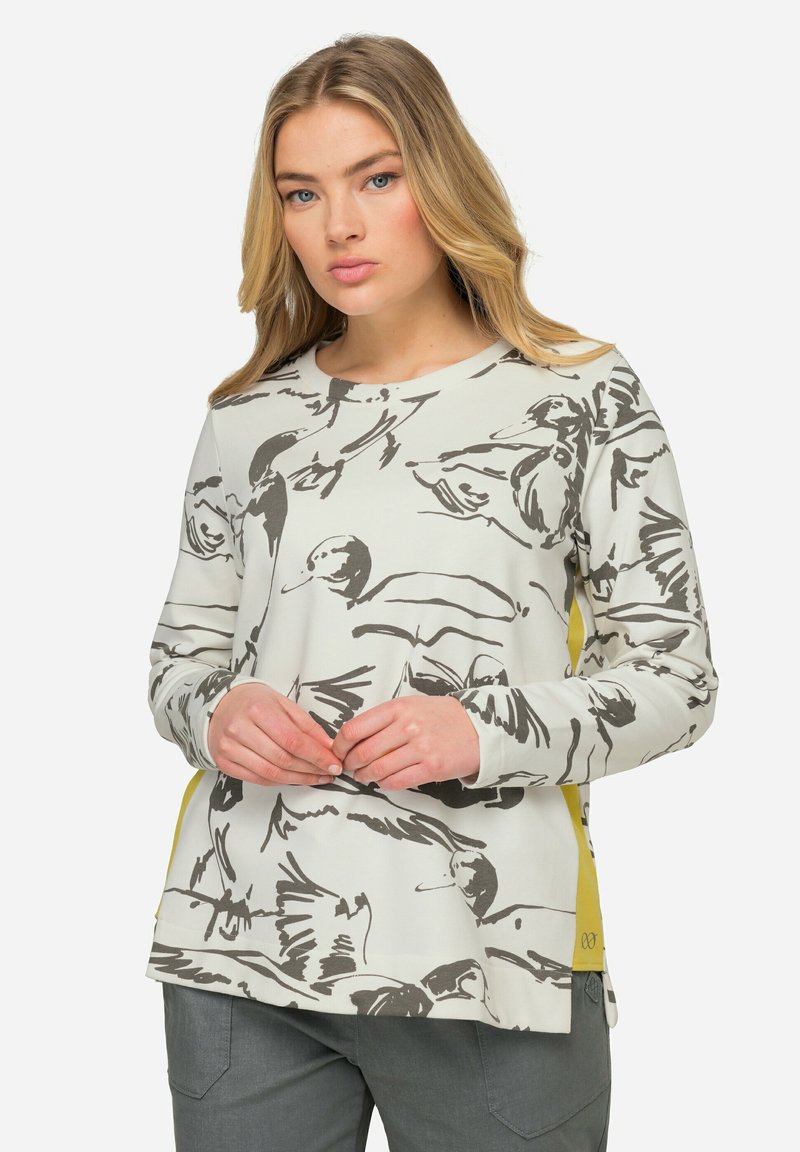 Sweatshirt gris clair avec un imprimé d'oiseau noir, col rond, manches longues et accents jaunes sur les côtés, fabriqué en tissu doux.