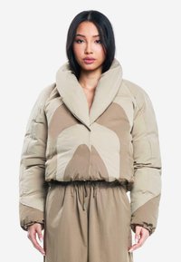 Abrigo de plumas beige con un amplio collar, que presenta grandes formas abstractas en tonos claros y oscuros; textura acolchada y cintura elástica.
