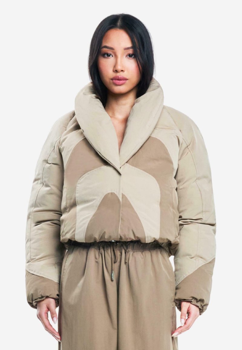 Abrigo de plumas beige con un amplio collar, que presenta grandes formas abstractas en tonos claros y oscuros; textura acolchada y cintura elástica.