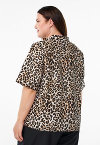 Beige, bruine en zwarte leopardenprint korte mouwen shirt. Glad stof met een ontspannen pasvorm en kraag, met een minimalistisch ontwerp.