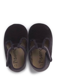 Zapatos de terciopelo negro con una textura suave, forma de punta redondeada y una correa segura. La plantilla interior presenta el nombre de la marca impreso "Pisamonas."