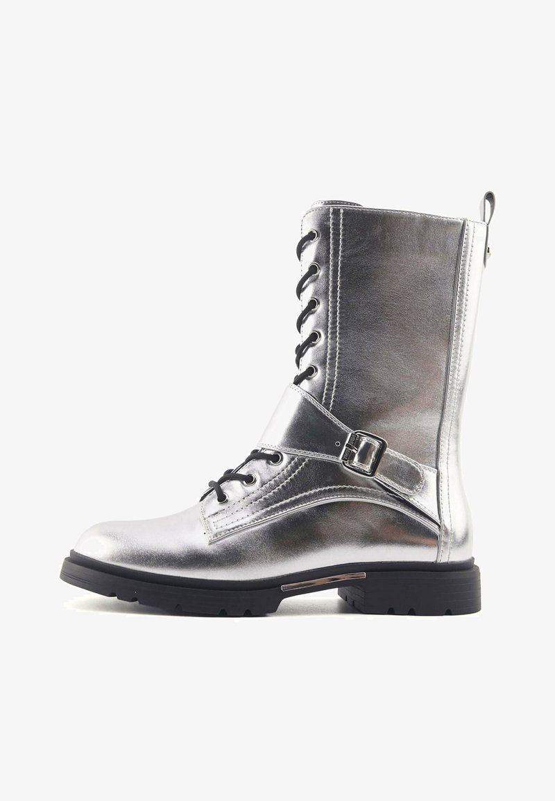 Srebrne metaliczne buty wojskowe z przodem na sznurówki, bocznym paskiem na klamrę i teksturowaną cholewką. Posiadają wytrzymałą czarną gumową podeszwę.