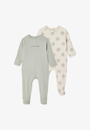 Two long-sleeve baby onesies, one solid light green with French text, one cream with large light gray polka dots, both footed and ribbed.