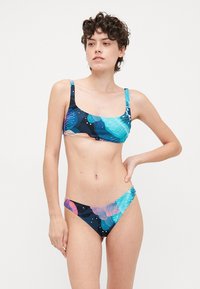 Bikini set s vrúbkovým topom a spodným dielom s nízkym pásom. Tkanina má kvetinový vzor v teal, ružovej a modrej farbe na tmavom pozadí.