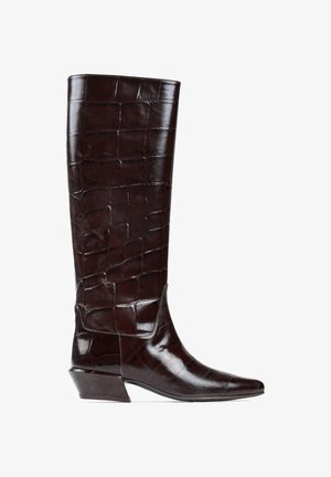 Brązowy skórzany but za kolano z teksturą krokodyla, spiczastym czubkiem i ukośnym obcasem. Gładkie wykończenie i brak widocznych elementów metalowych lub akcentów.