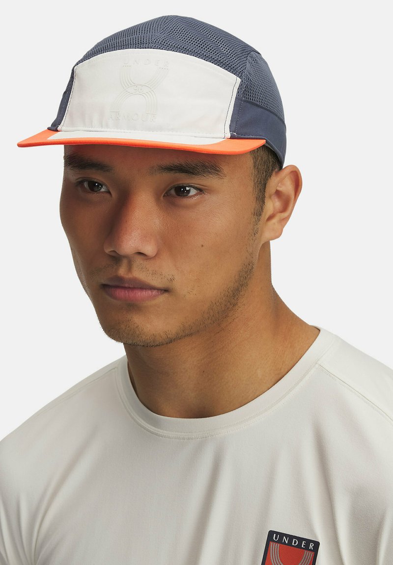 Gorra con cuerpo de malla azul marino, panel frontal blanco y visera naranja. Presenta un logotipo grabado en el panel frontal y un acabado texturizado.