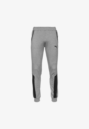 Pantalon de survêtement gris Puma avec bandes latérales noires, taille et poignets élastiques, et poches zippées de chaque côté.