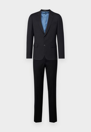 Schwarzer Anzug mit einem Blazer mit zwei Knöpfen, einem Reverskragen und Seitentaschen, kombiniert mit maßgeschneiderten Hosen. Das Innere hat ein blaues Futter.