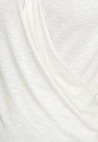 Weißer strukturierter Stoff, der in sanften Falten drapiert ist und ein leichtes, leicht durchsichtiges Erscheinungsbild mit einer feinen, gleichmäßigen Webart zeigt.