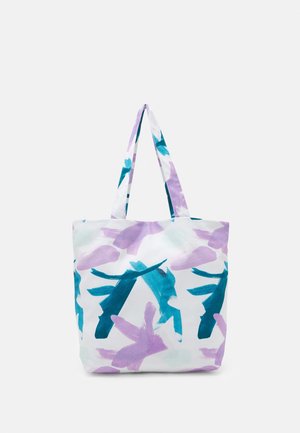 Witte tote tas met paarse en blauwgroene abstracte penseelstreekpatronen en bijpassende stoffen handvatten op een effen achtergrond.