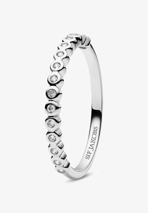 Sølvring med en række runde, klare sten sat i cirkulære indtryk rundt om ringen, hvilket skaber et glat, struktureret udseende.