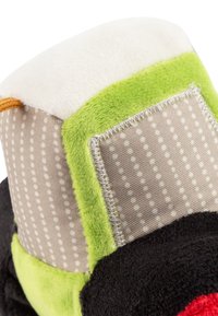 Multicolored plush toy with green, black, red, and beige fabric. Features a soft white top, polka dot patterns, and visible stitching details.