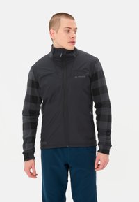 Giacca nera con zip frontale, caratterizzata da una parte superiore uniforme e maniche a fantasia a scacchi. Il materiale sembra leggero con polsini elastici.