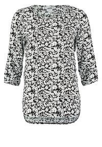 Top a maniche lunghe bianco e nero con un motivo astratto, scollatura rotonda e orlo leggermente curvo. Tessuto leggero e liscio.