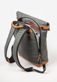Gray backpack with brown leather accents, zippered compartments, padded straps, and a textured interior. Features a roll-top design for versatility.