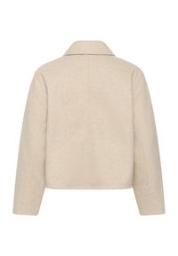 Veste en mélange de laine beige avec un col, coupe droite, coutures visibles et manches longues, présentant une finition en tissu texturé.