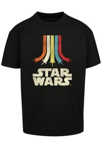 Melna kokvilnas t-krekls ar retro stila grafiku, kurā ir krāsainas svītras un "STAR WARS" teksts novecojušā krējuma krāsā.