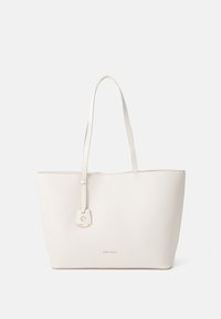Light beige tote bag made of textured material, featuring two long handles and a decorative padlock accent on the front.