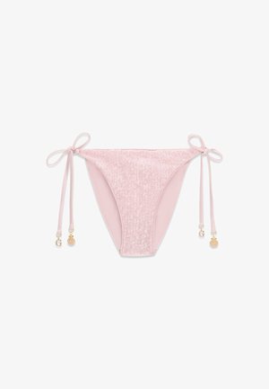 Bas de bikini rose pâle avec liens sur les côtés, présentant une lettre "G" dorée et des breloques en forme de coquillage, texturés avec des détails subtils de sequins.