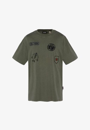 T-shirt vert olive à manches courtes avec des écussons de style militaire, dont "US 740N", un emblème de parachute et un bouclier avec un chiffre 3 rouge.