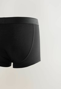 Mustat puuvillaboksereiden shortsit, joissa on sileä pinta, logoitu elastinen vyötärö ja kontrastiväriset ompeleet sivuilla.
