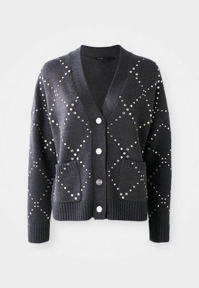 Atslēgas pelēks kardigans ar V-veida kaklu, rotāts ar sudraba dažādām kapēm dimantu rakstā, ar divām priekšējām kabatām un baltām pogām.