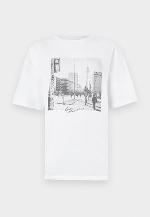 Λευκό βαμβακερό μπλουζάκι με μαύρη και άσπρη φωτογραφία ενός αστικού τοπίου και την υπογραφή "LaLa Berlin" στο κάτω μέρος. Κοντά μανίκια, άνετη εφαρμογή.