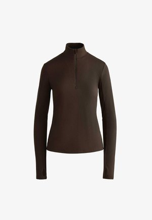 Top lung cu maneci lungi, de culoare maro, cu un guler înalt și un design cu fermoar până la jumătate. Materialul are o textură interesantă și găuri pentru degete în mâneci.