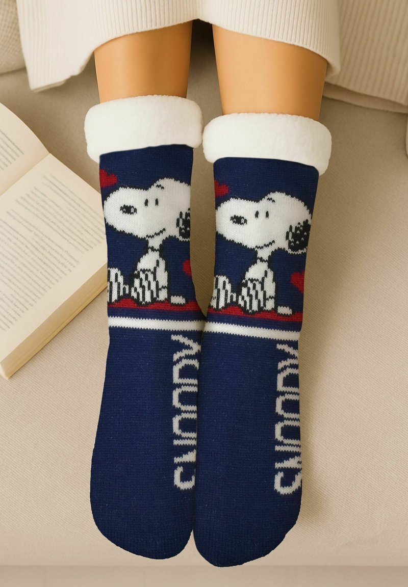 Navy blue socks featuring a white and black Snoopy design with red accents. Soft, fuzzy white cuffs. Knit texture with text "Snoopy" on the foot.