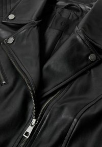 Zwarte leren jas met een ritssluiting aan de voorkant, drukknoopsluitingen en geruite details. Soepele textuur met metalen accenten.