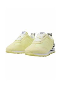 Yellow suede sneakers with a sleek design, featuring black and white striped accents on the heel and white laces.