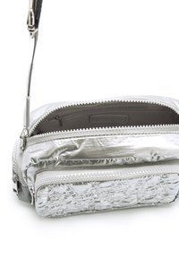 Silberne metallic Crossbody-Tasche mit strukturierter Oberfläche, ausgestattet mit zwei Reißverschlussfächern und einem abnehmbaren Tragegurt für Vielseitigkeit.
