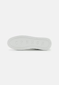 Witte rubberen sneakersole met een gestructureerd oppervlak, voorzien van reliëflettering "CPNHGN" en een patroon van kleine fietsen rondom de rand.