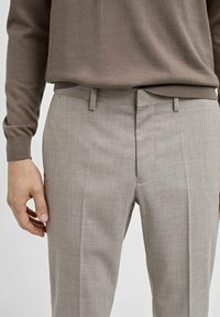 Šedé kostkované kalhoty s přizpůsobeným střihem, vyrobené z lehké tkaniny. Obsahují poutka na opasek a plochý přední design.